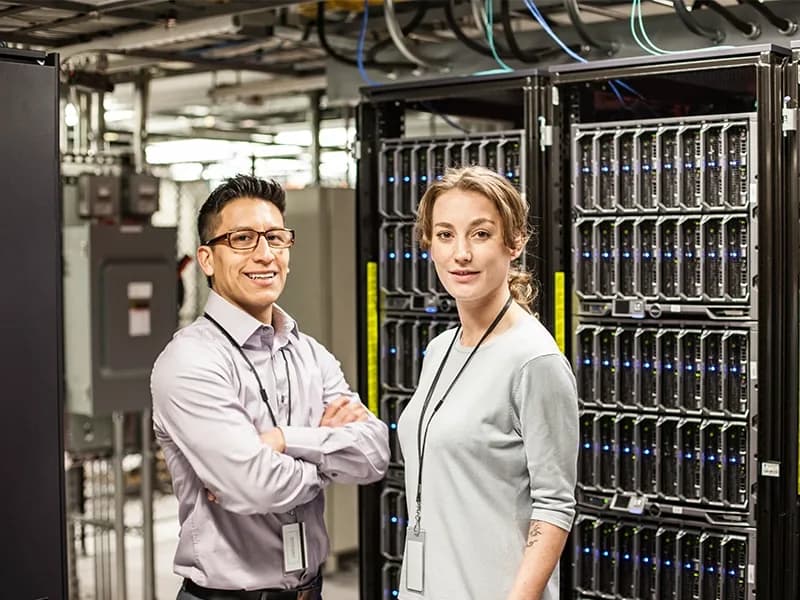 Two infrastructure engineers standing in a server room