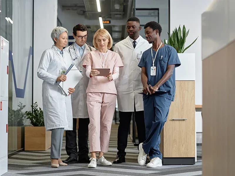 Clinicians and administrators walking together through a hospital corridor
