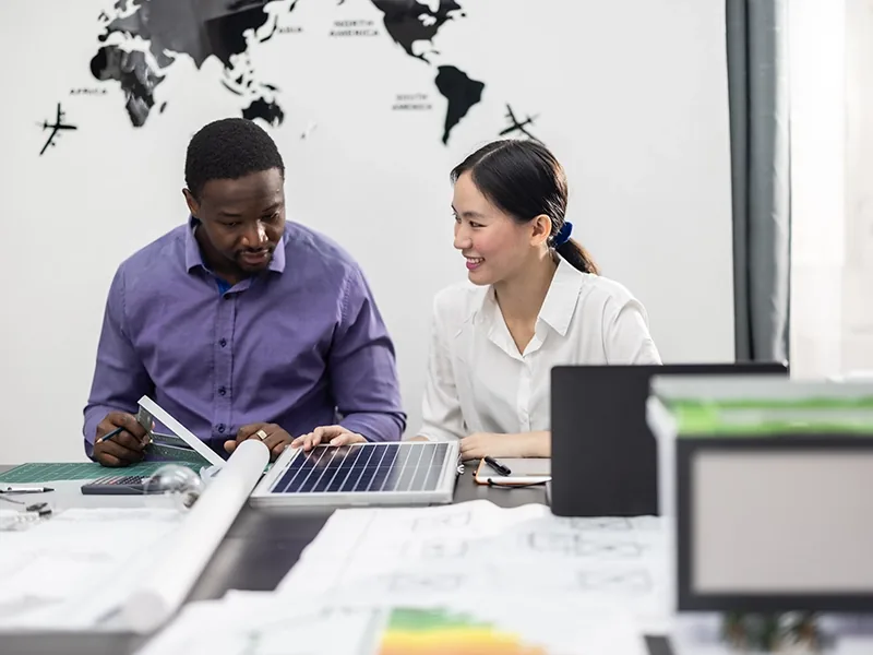 Two colleagues reviewing a system rollout plan at a shared desk